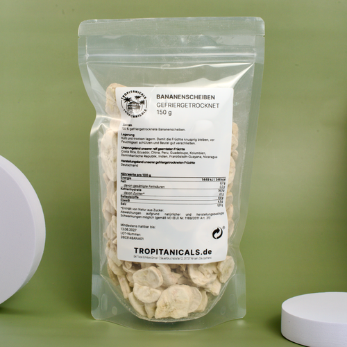 Gefriergetrocknete Bananenscheiben vor grünem Hintergrund mit weißen Dekoelementen