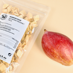 Doypack mit gefriergetrockneter Mango liegt neben einer ganzen Mango